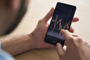 A man looking at investment performance on his phone. 