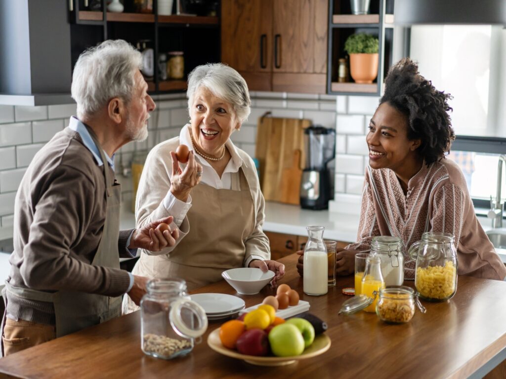 Parents talking to their adult child in their kitchen.
